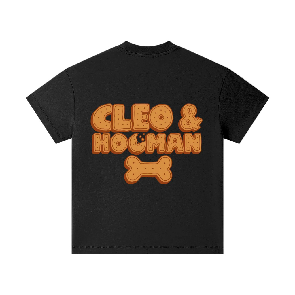 A black short-sleeve t-shirt with a graphic on the front reading 'CLEO & HOoMAN' in orange cookie-style letters with a bone icon below, shown on a plain white background.