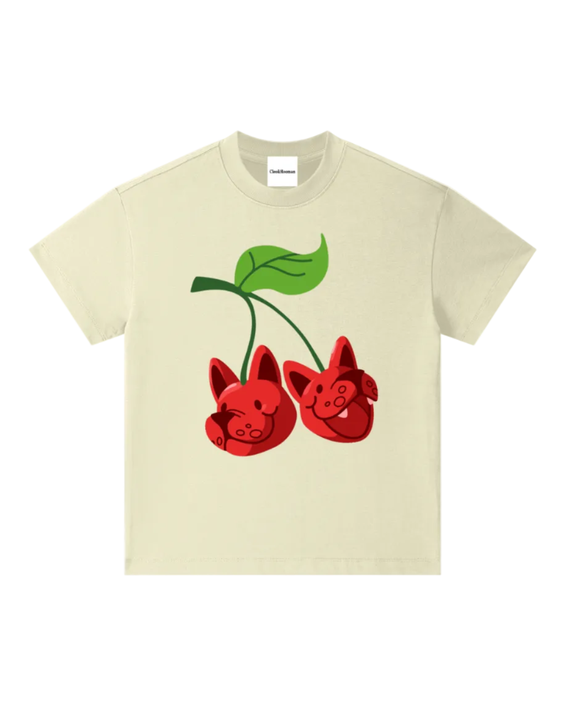A cream-colored short-sleeve t-shirt featuring a graphic of two red cherries with pig faces and green leaves, displayed on a solid white background.
