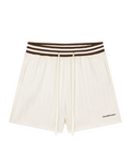Off-white pleated shorts with a brown and white striped elastic waistband, featuring a drawstring and a small black 'Cocktail Man' logo on the lower left hem, shown against a plain white background.