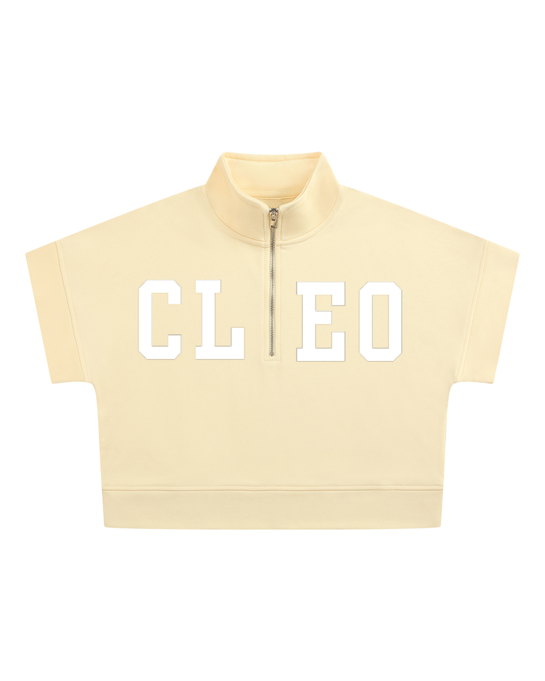 A cream-colored short-sleeve crop top with a half-zip mock neck collar, featuring the letters 'CLEO' printed in white across the chest.