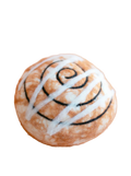Baked good with white icing and black swirls on a beige background