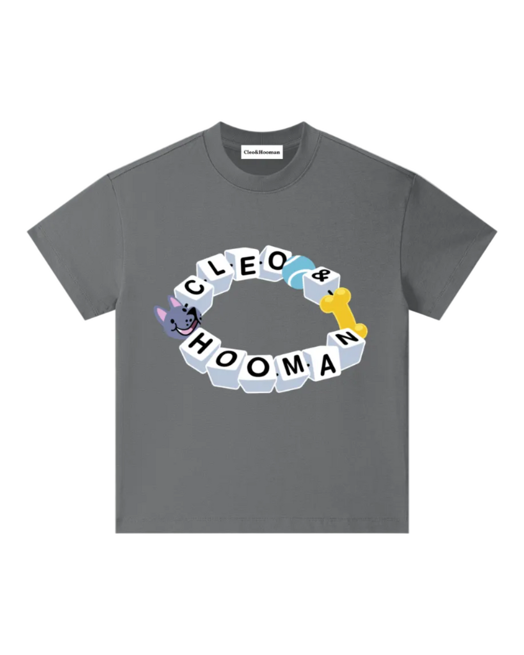 A dark gray crewneck t-shirt featuring a circular graphic on the chest with the words 'Cleo & Hooman' spelled out in white block letters, accented by a purple cat illustration and a yellow dog bone.